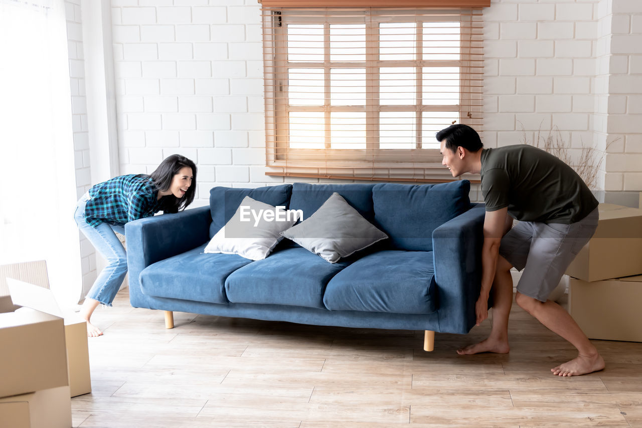 FULL LENGTH OF YOUNG COUPLE IN SOFA