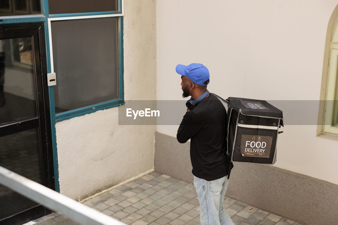 rear view of man standing in front of building