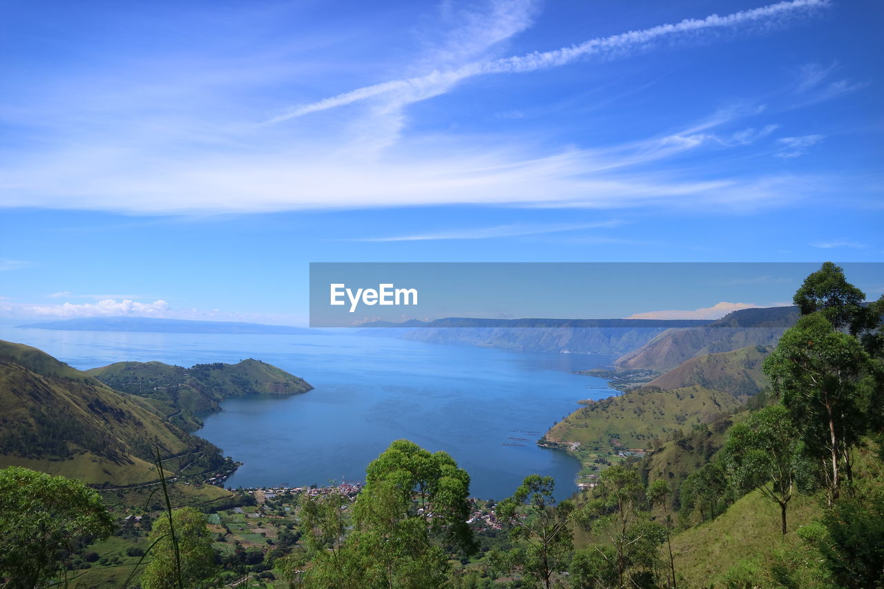 Scenic view of sea and mountains against sky