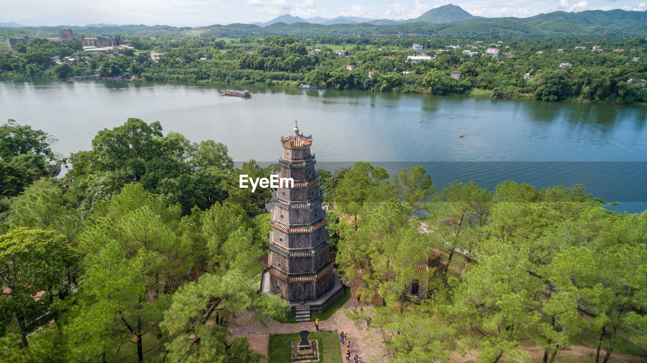 HIGH ANGLE VIEW OF PLANTS AND RIVER AGAINST TREES