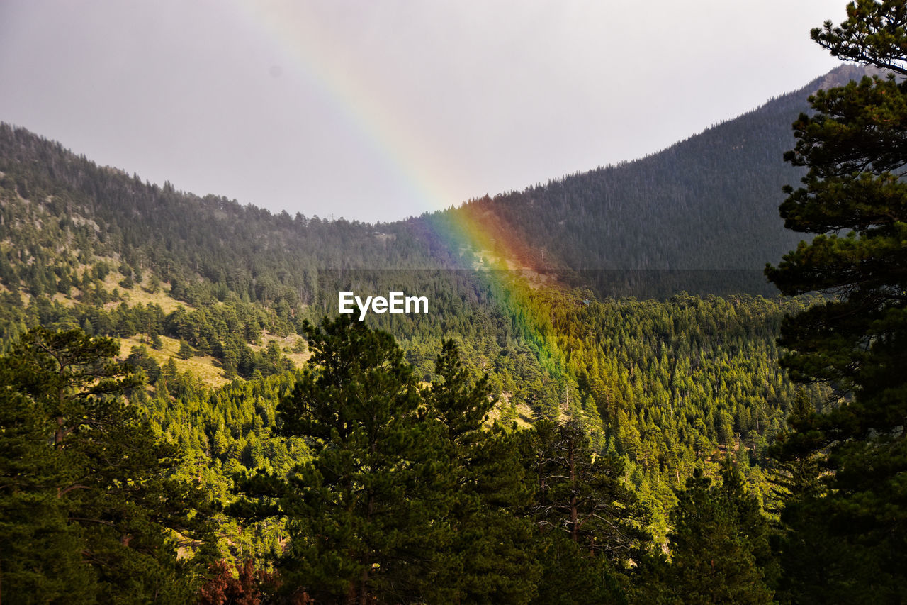 Scenic view of rainbow over mountains against sky