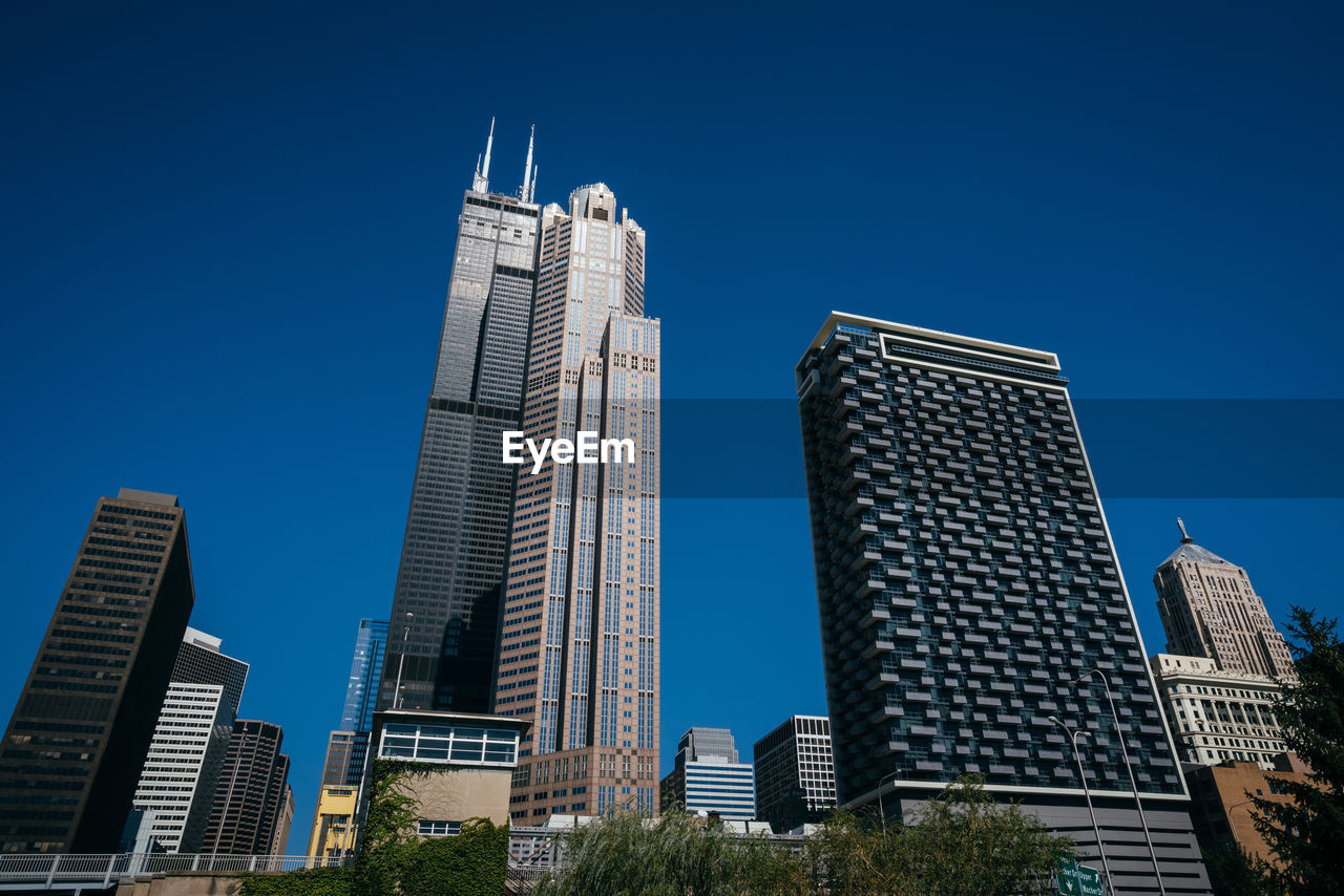 LOW ANGLE VIEW OF BUILDINGS IN CITY AGAINST BLUE SKY