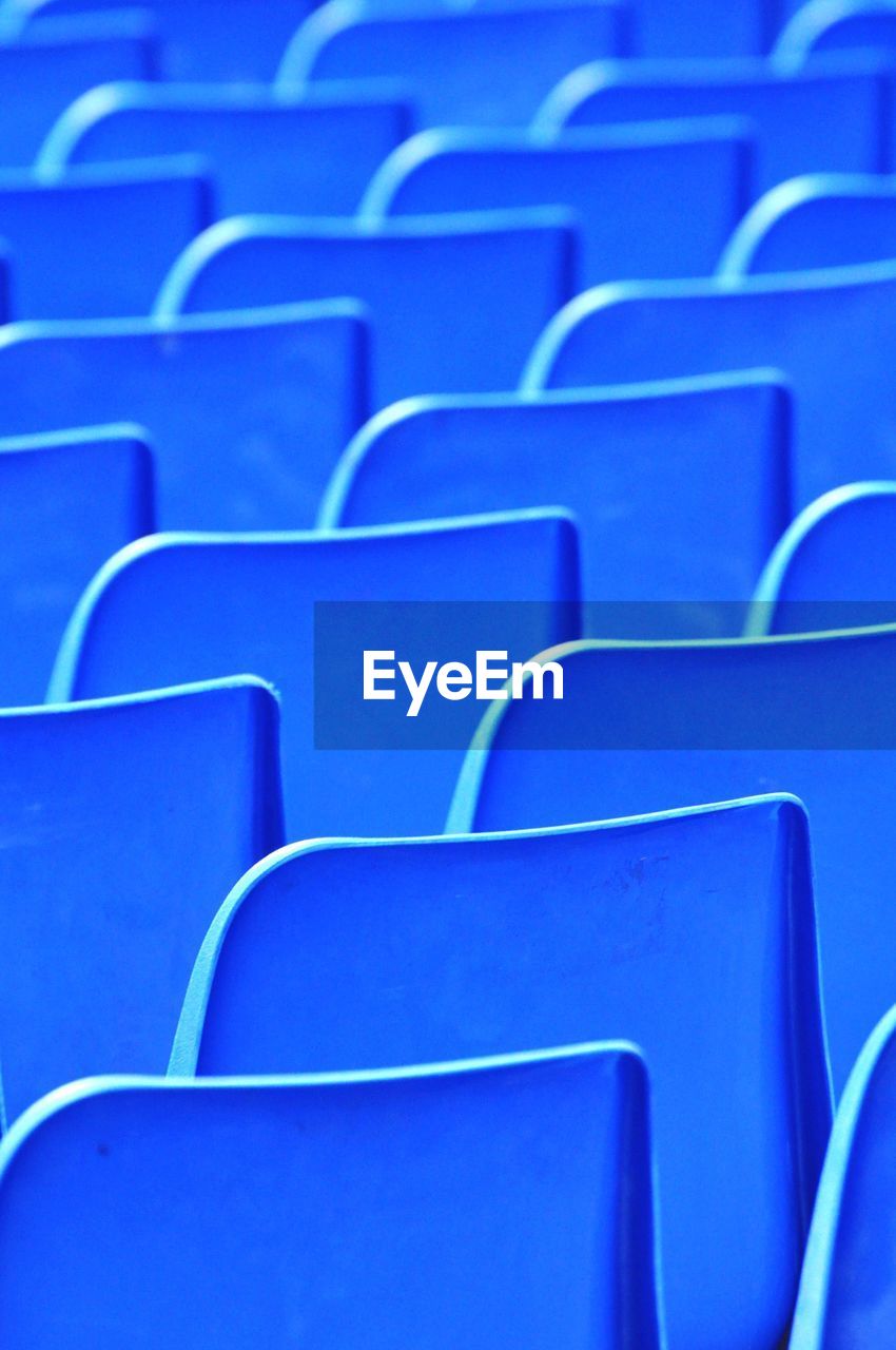 Full frame shot of empty blue chairs