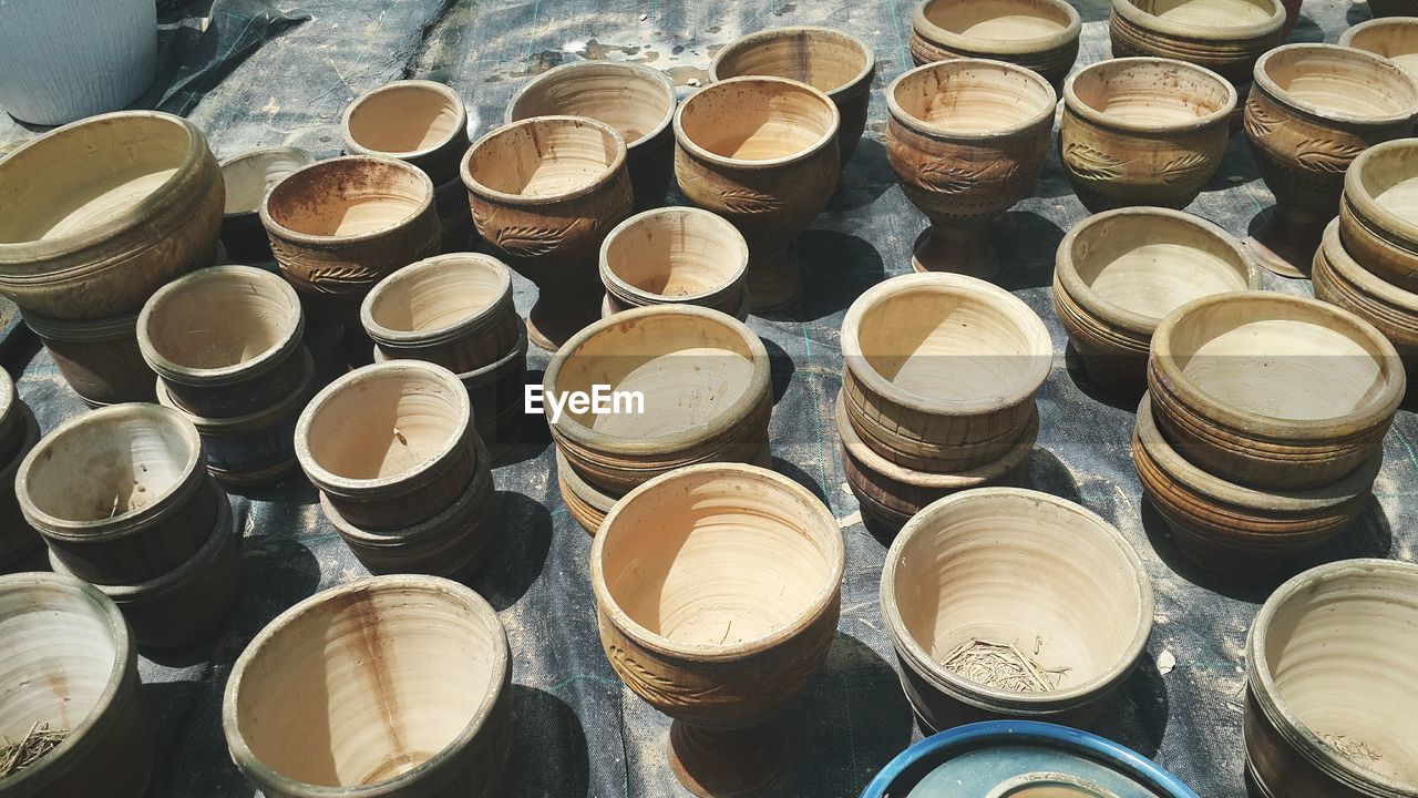 HIGH ANGLE VIEW OF STACKED ARRANGED IN SHELF