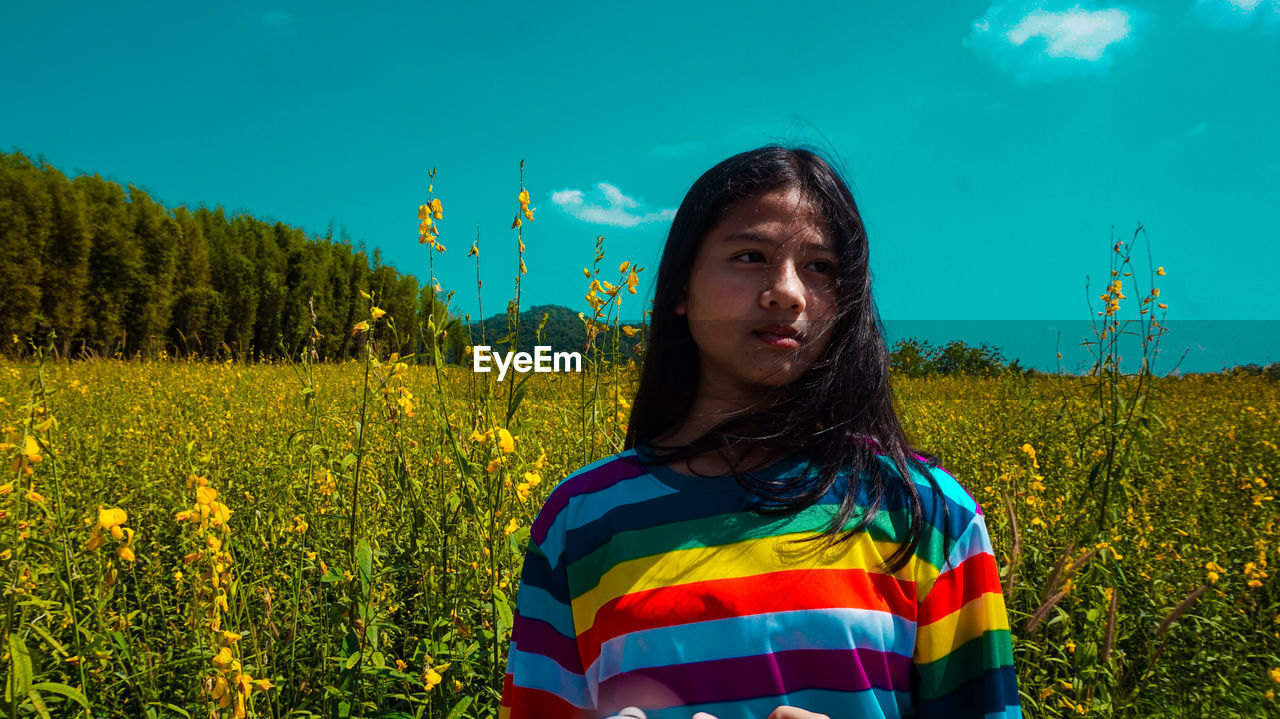 Woman looking away against flowering plants