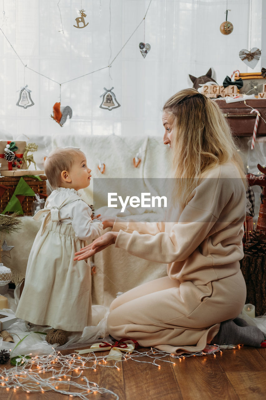 Smiling mother with daughter amidst decoration at home