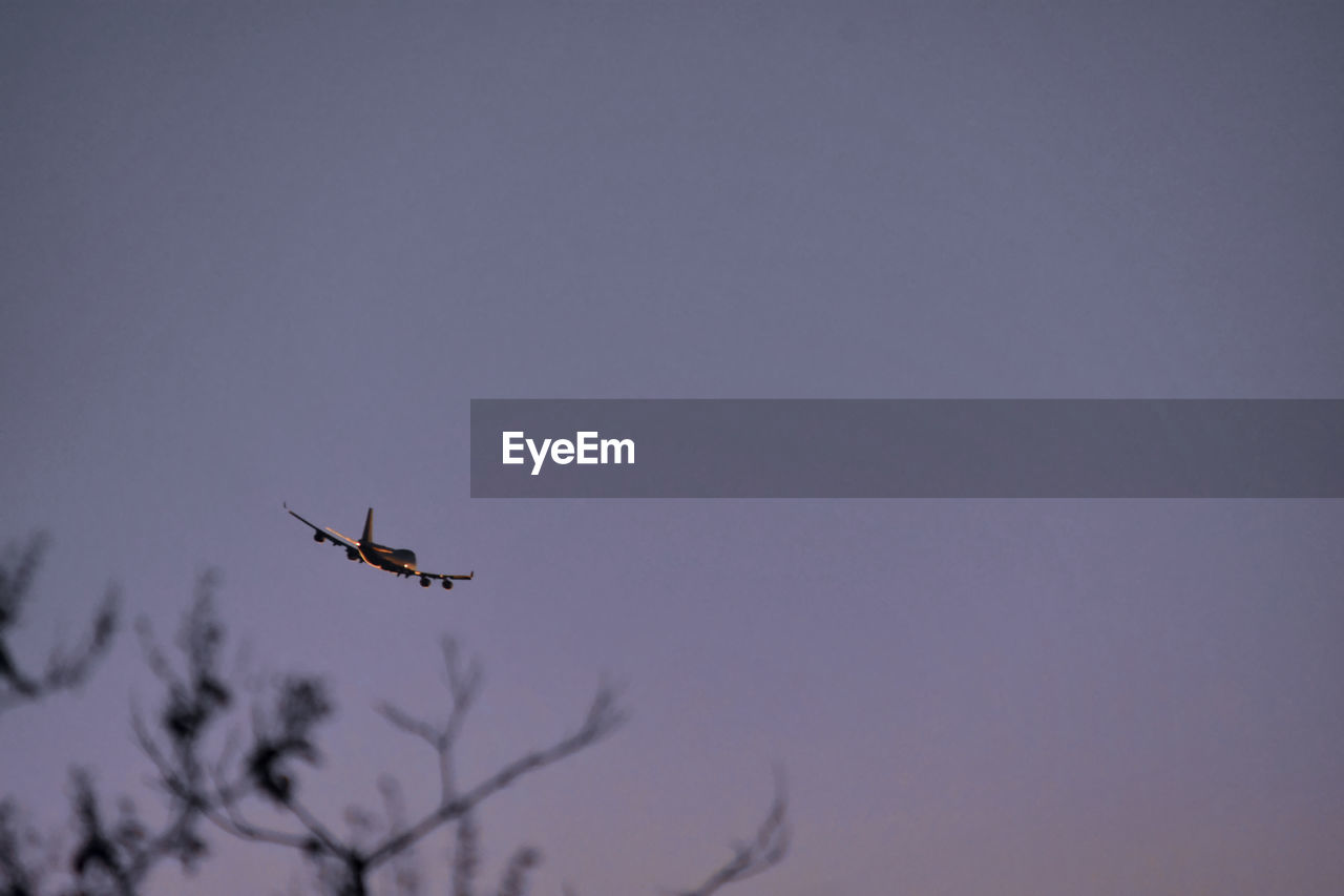 LOW ANGLE VIEW OF AIRPLANE IN FLIGHT AGAINST CLEAR SKY