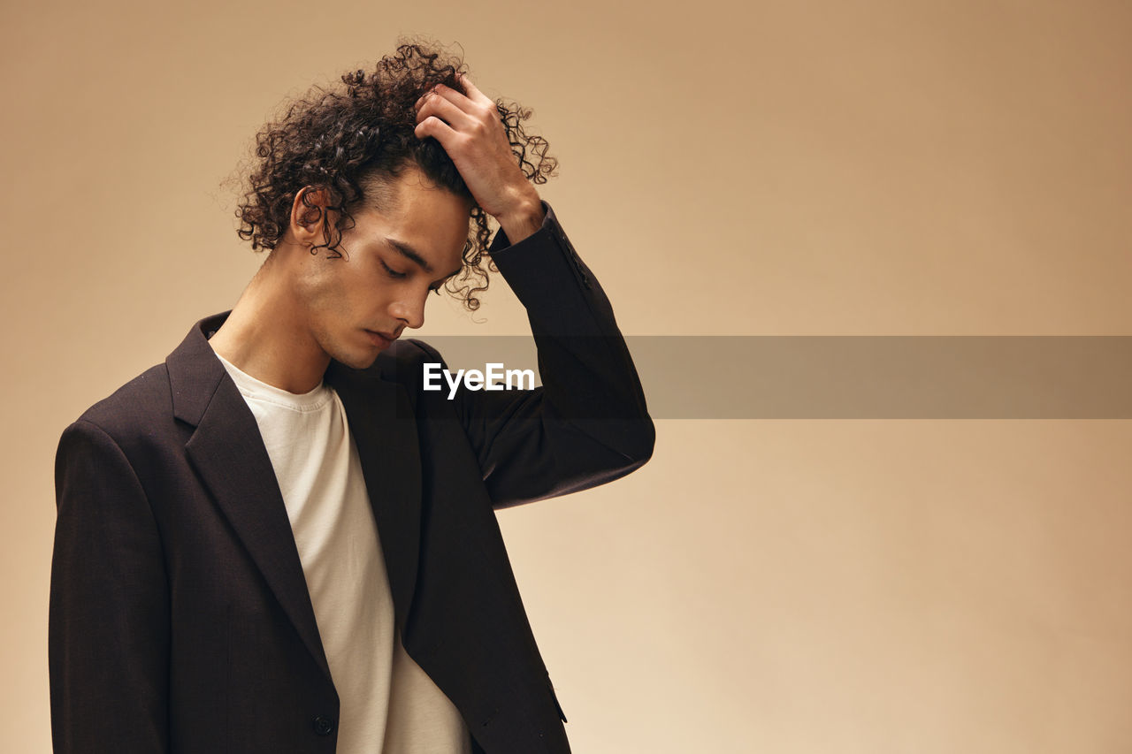 side view of young man looking away against sky