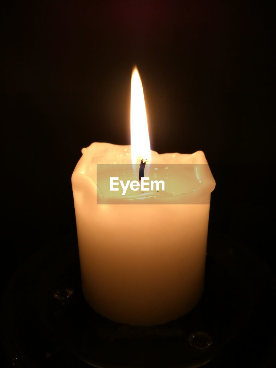 CLOSE-UP OF LIT CANDLE