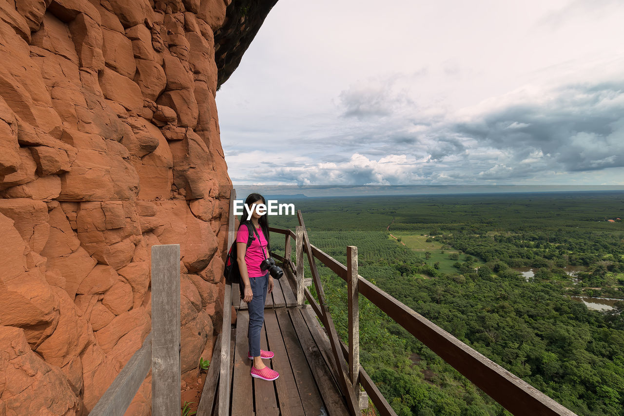 WOMAN STANDING ON RAILING