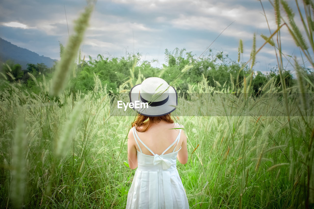 Woman standing with her back in the middle of the meadow