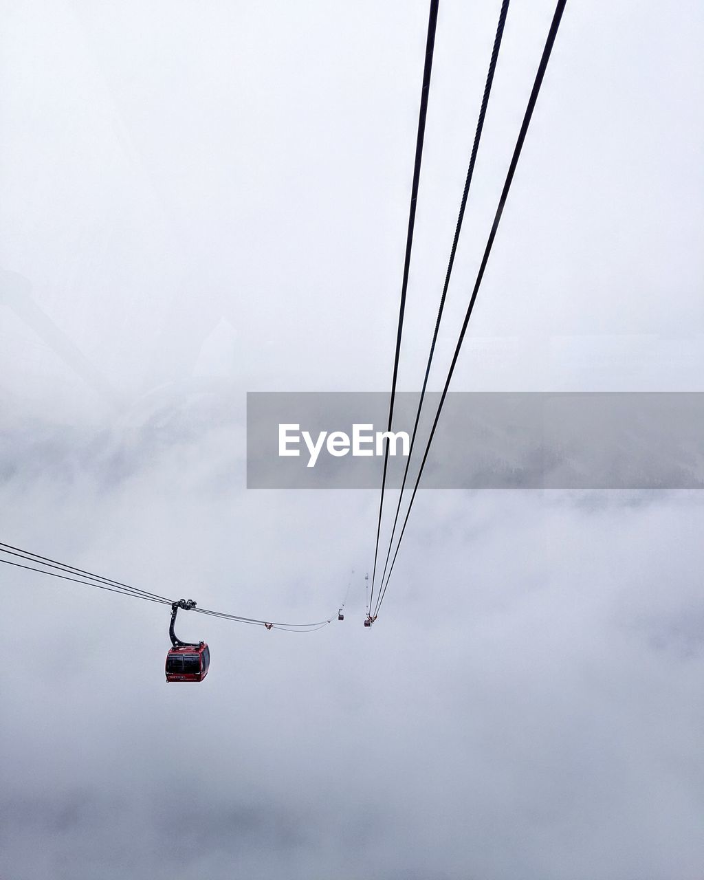 Low angle view of overhead cable car against sky