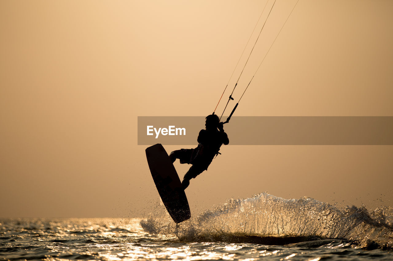 VIEW OF BOATS IN SEA AT SUNSET