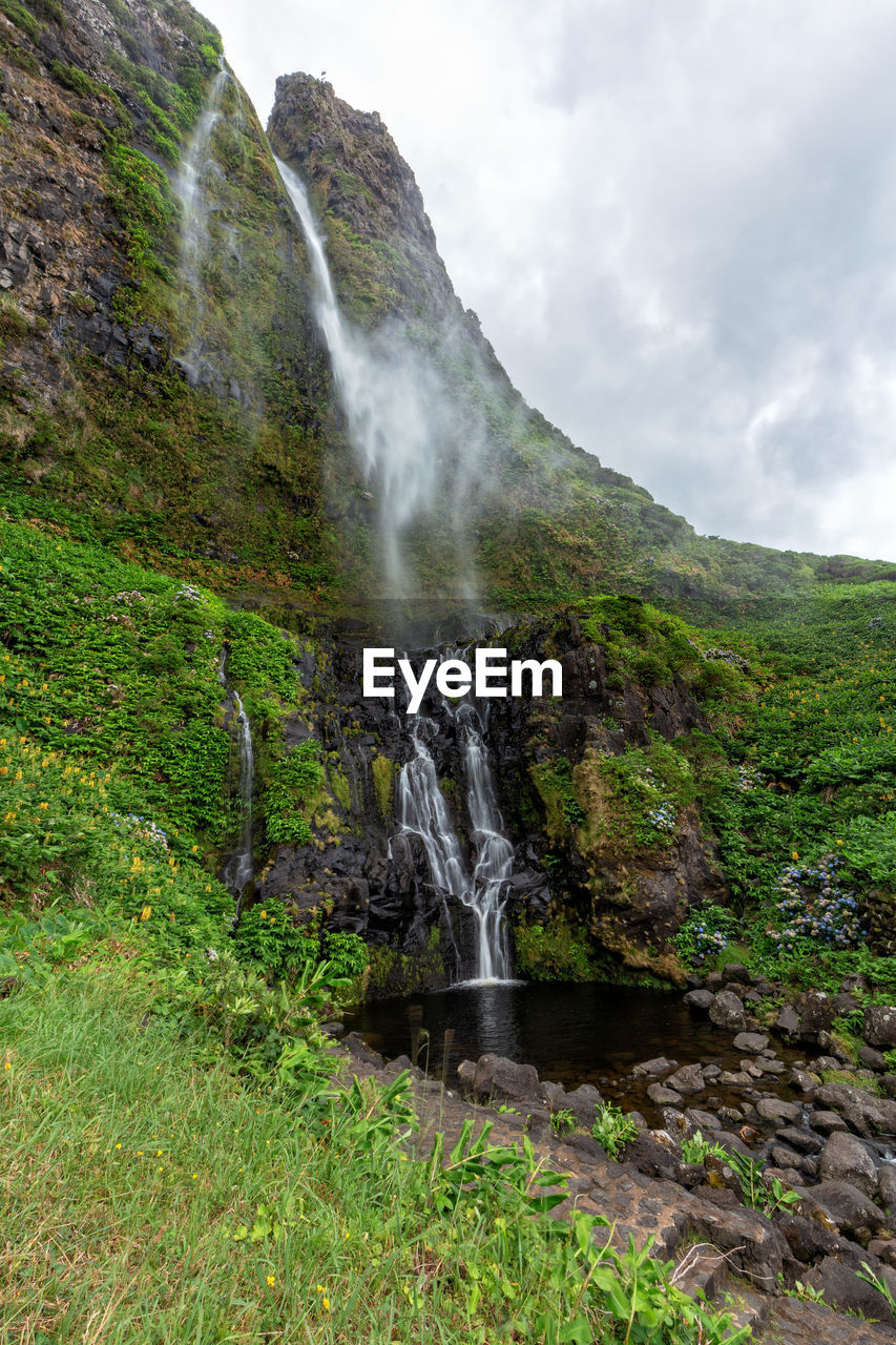 SCENIC VIEW OF WATERFALL AGAINST ROCKS