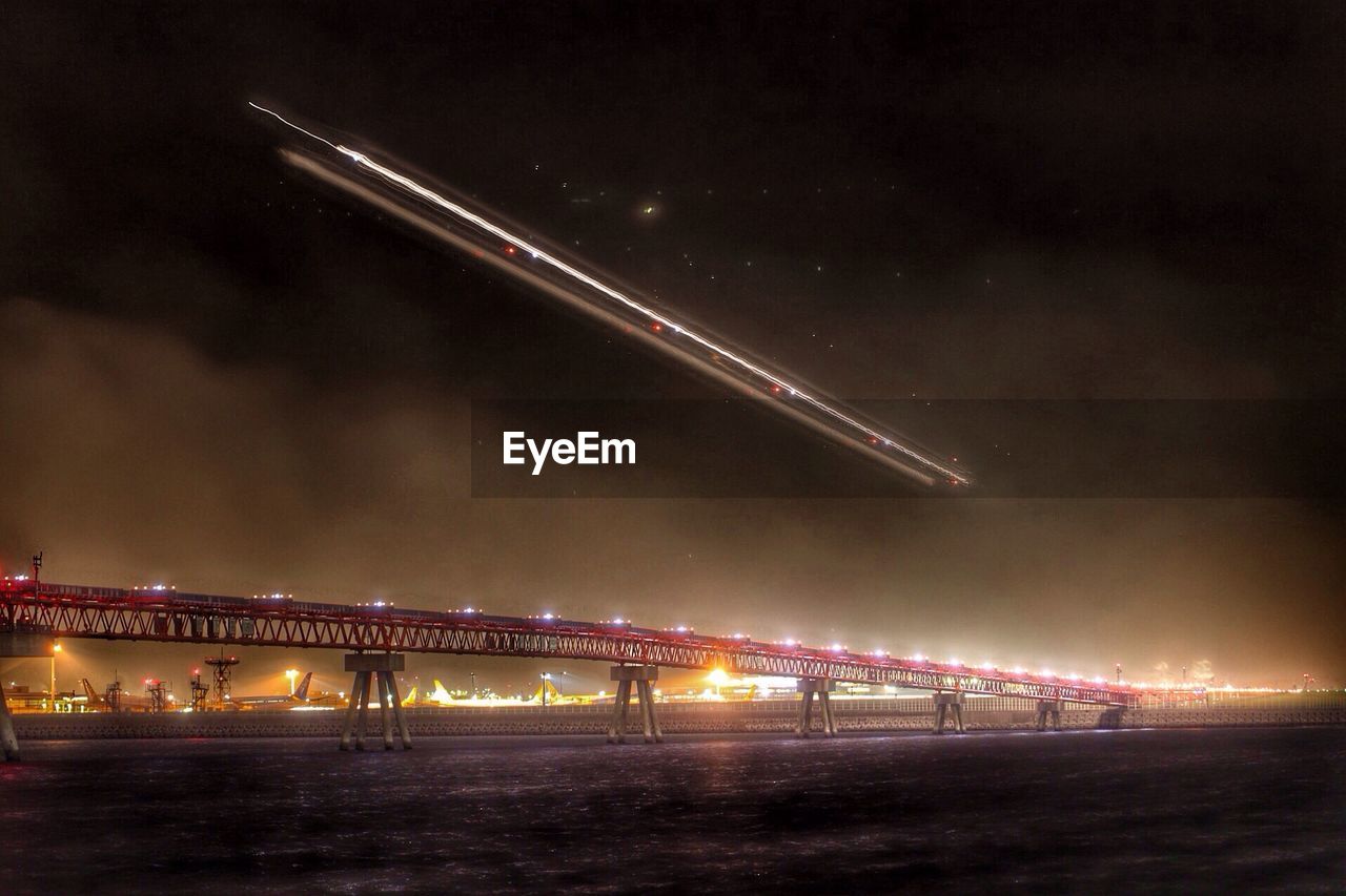 ILLUMINATED BRIDGE AGAINST SKY AT NIGHT