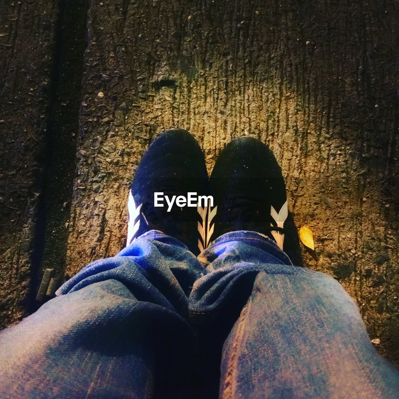 LOW SECTION OF MAN WEARING SHOES STANDING OUTDOORS