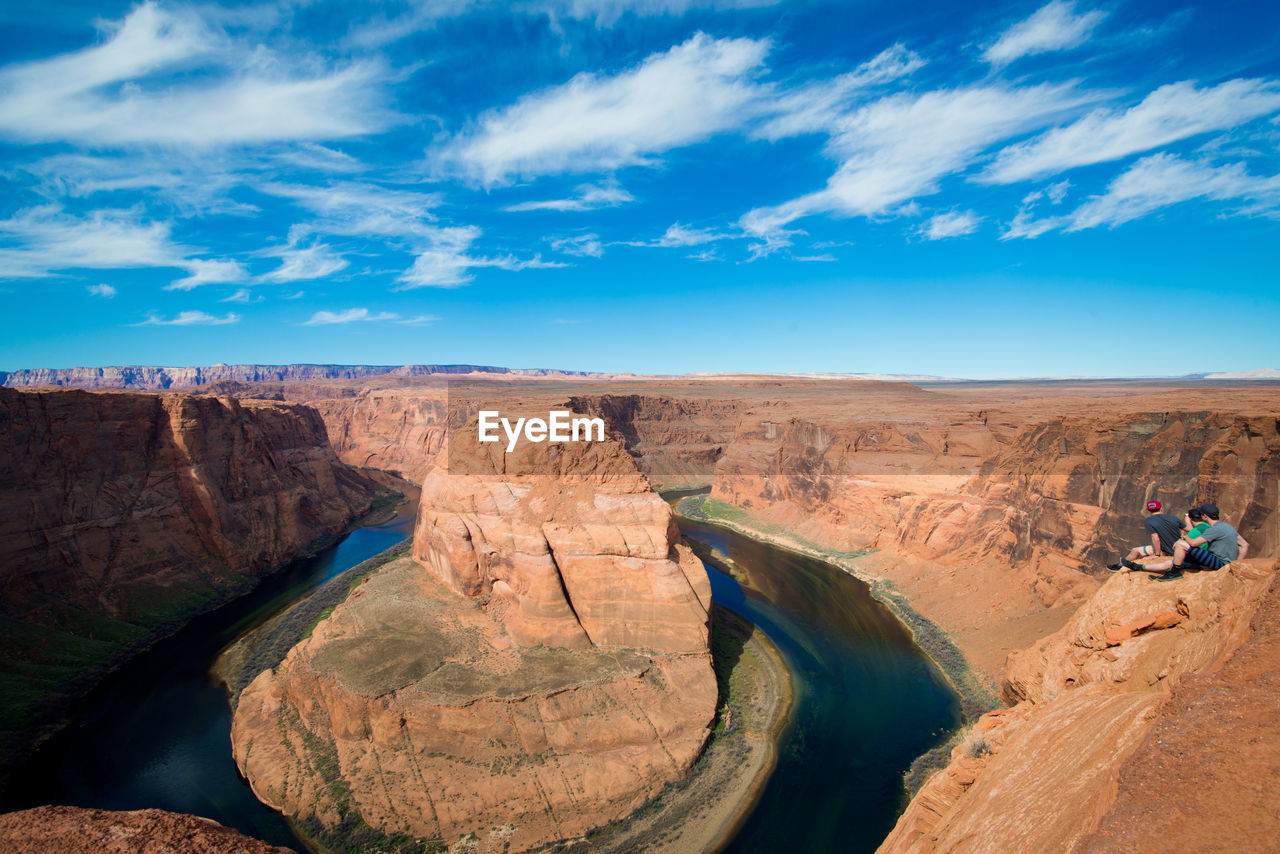 Hikers visiting horseshoe bend against sky