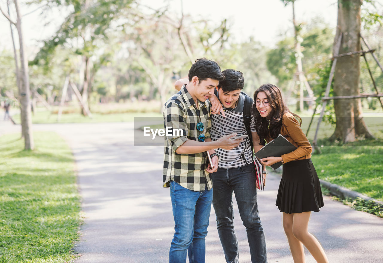 Friends using phone on road