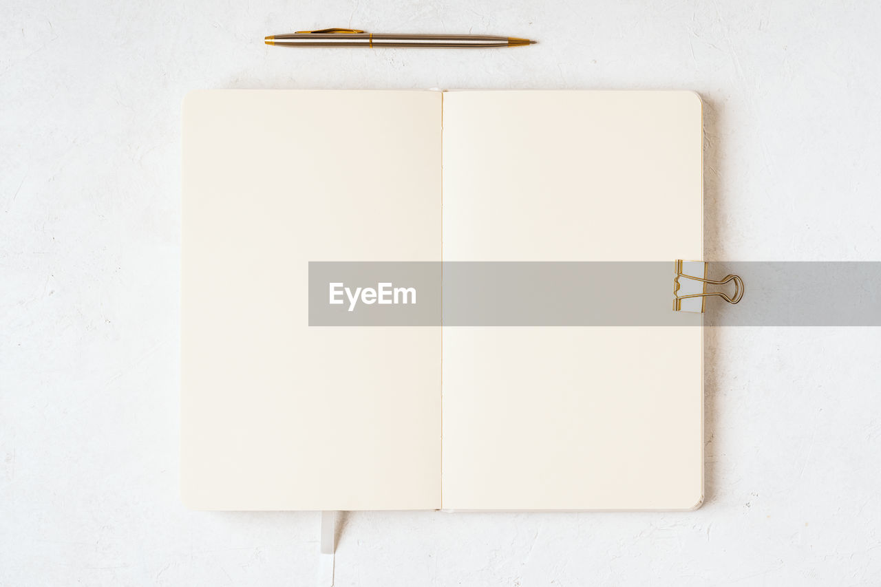 Top view blank paper notebook, and pen. desktop mock up, flat lay of white working table background