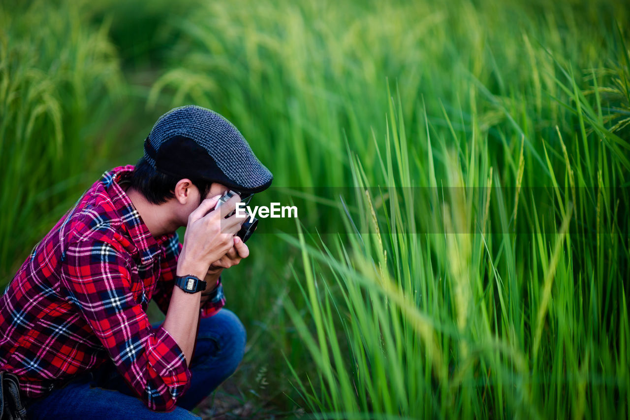 MAN SITTING ON FIELD