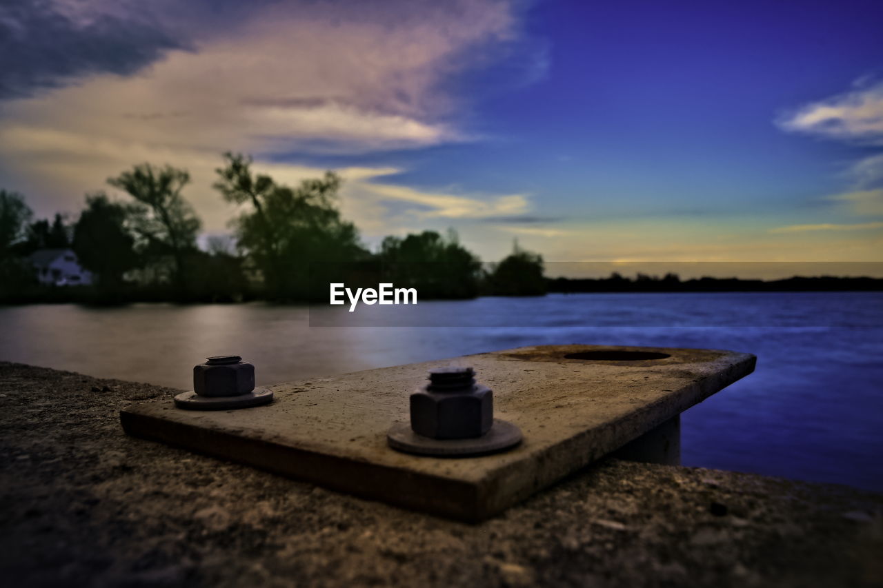 Boat on lake against sky at sunset