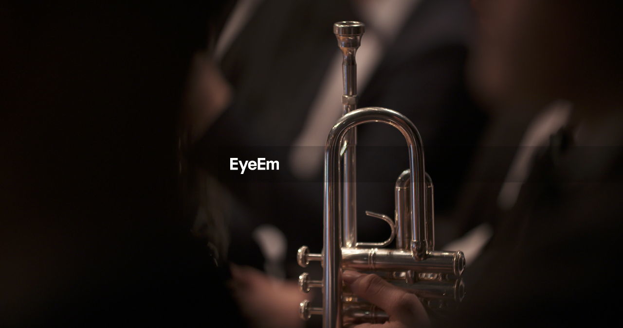 music, musical instrument, trumpet, arts culture and entertainment, brass instrument, musician, performance, close-up, indoors, saxophone, jazz music, one person, guitar, skill, selective focus, adult, metal, black background, studio shot