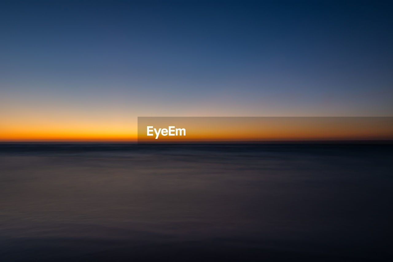 SCENIC VIEW OF SEA AGAINST ORANGE SKY