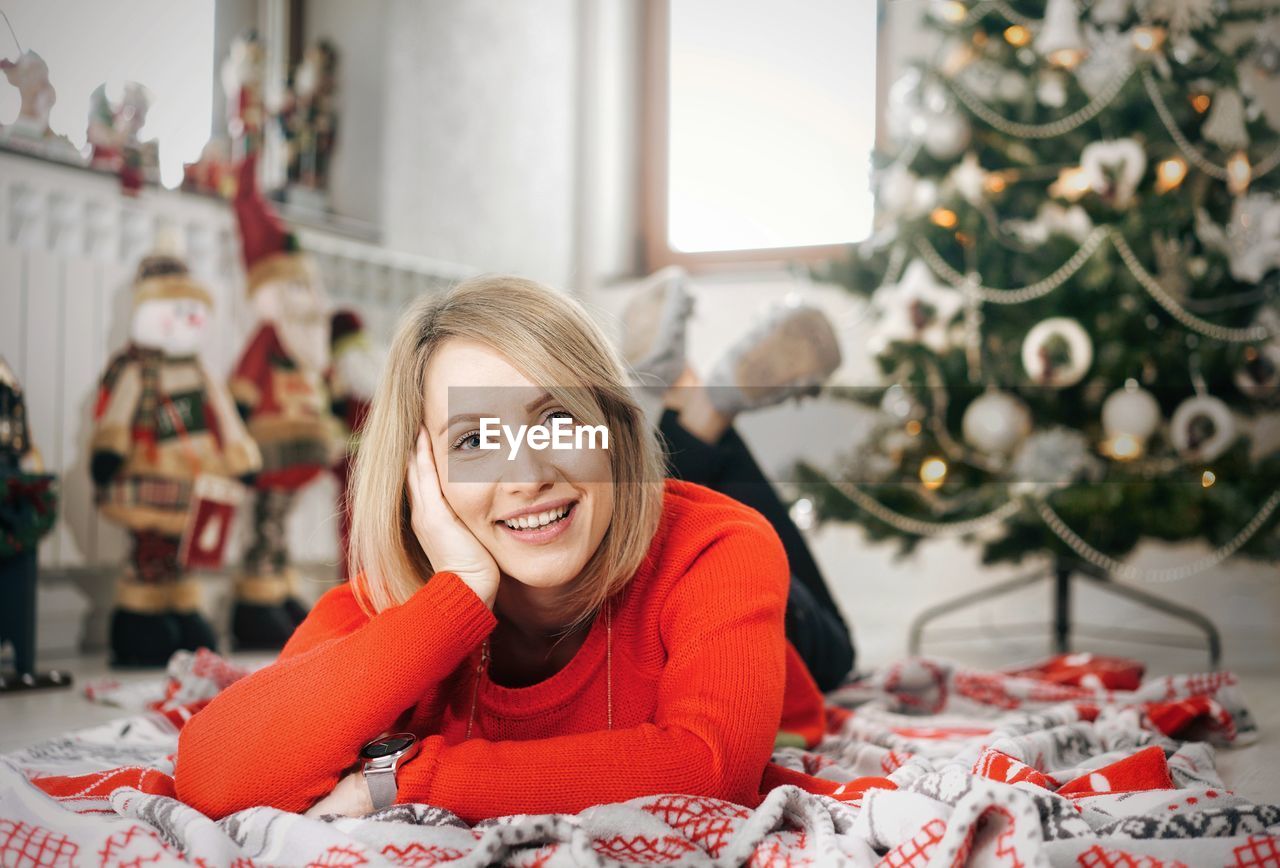 Portrait of smiling young woman lying on carpet