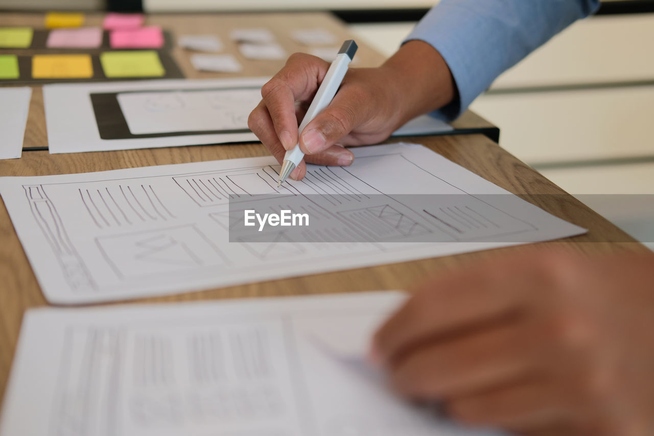 Cropped image of business person working at table in office