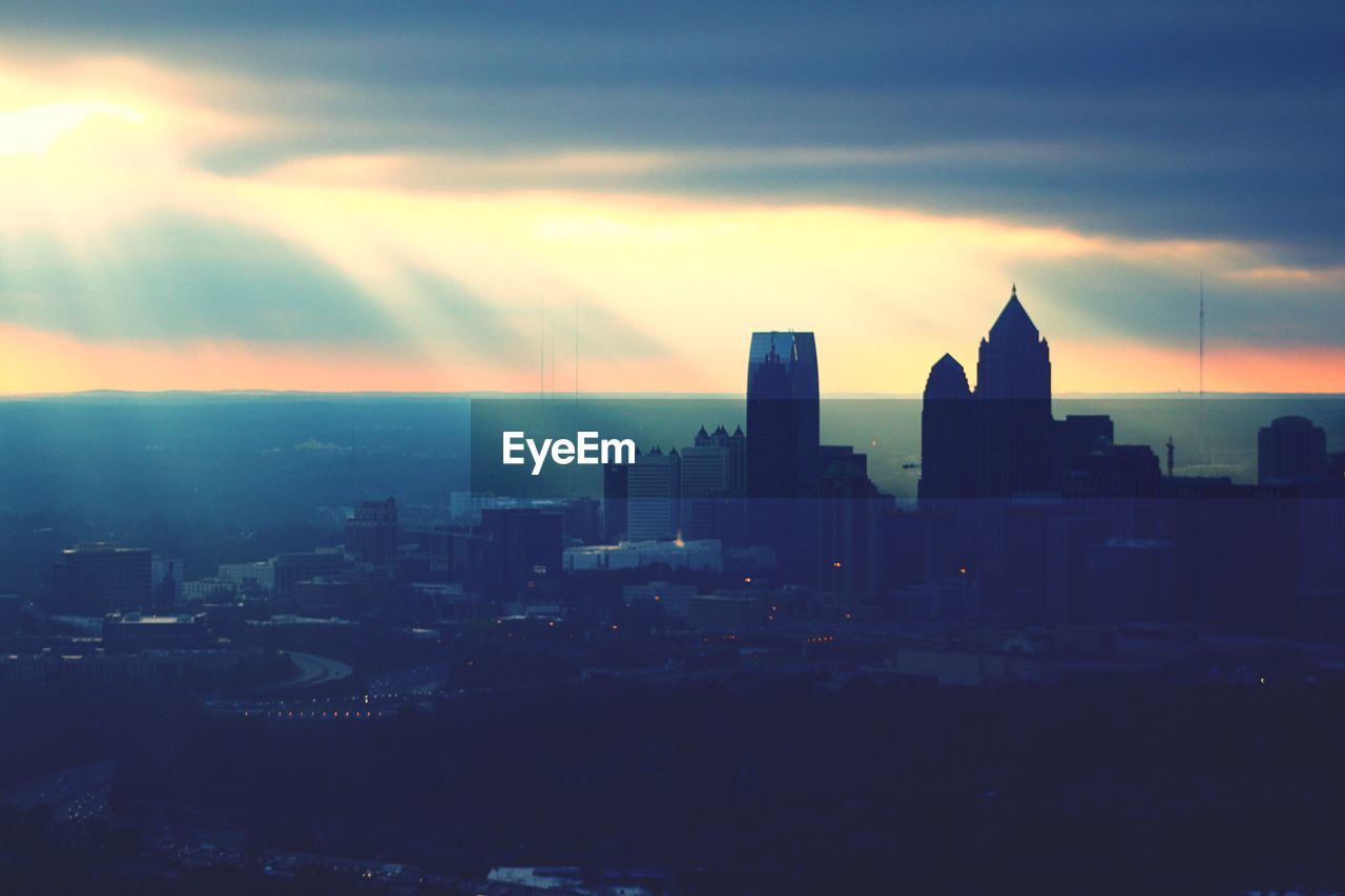 View of cityscape against cloudy sky during sunset