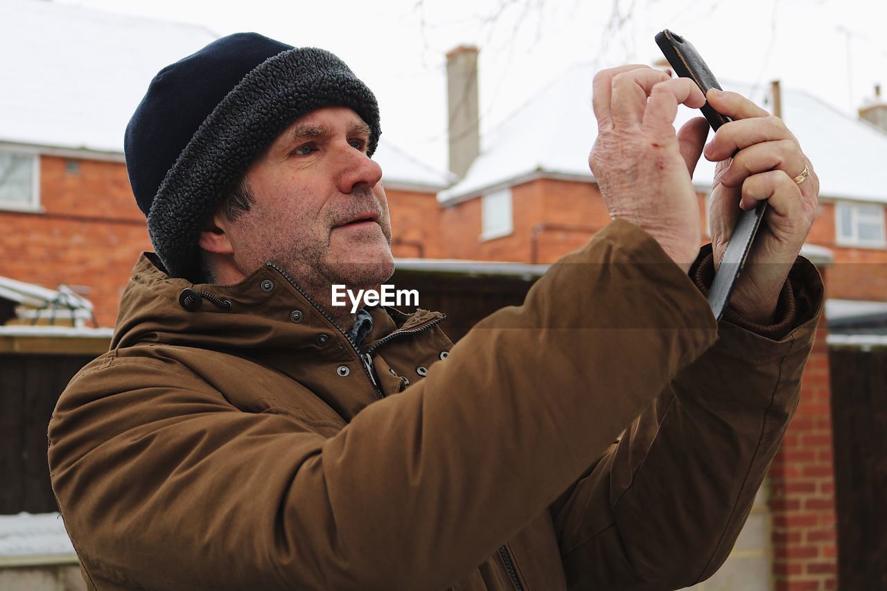 Close-up of man photographing through mobile phone