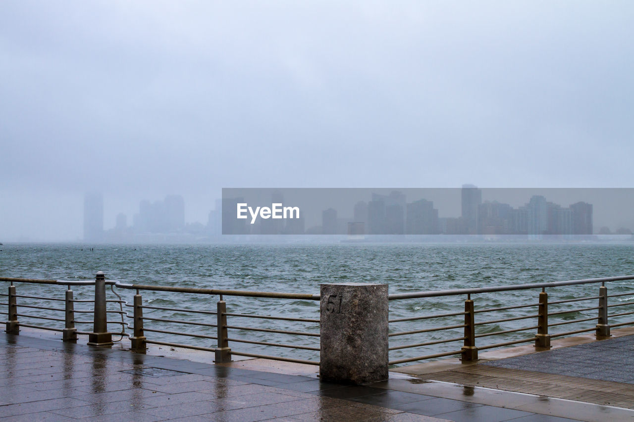 Skyline seen from promenade by sea in foggy weather