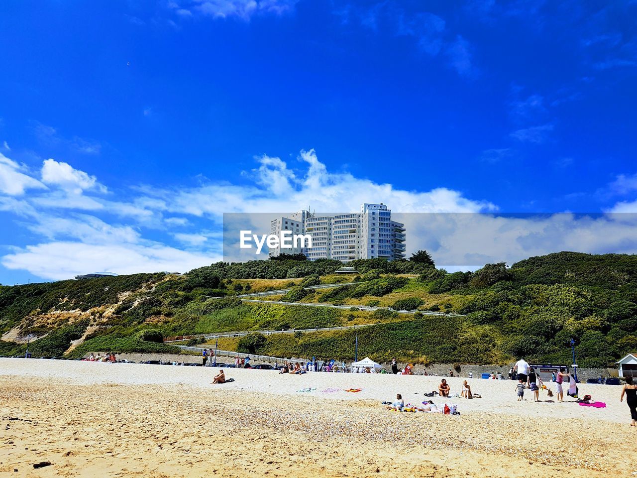 Group of people on beach against blue sky