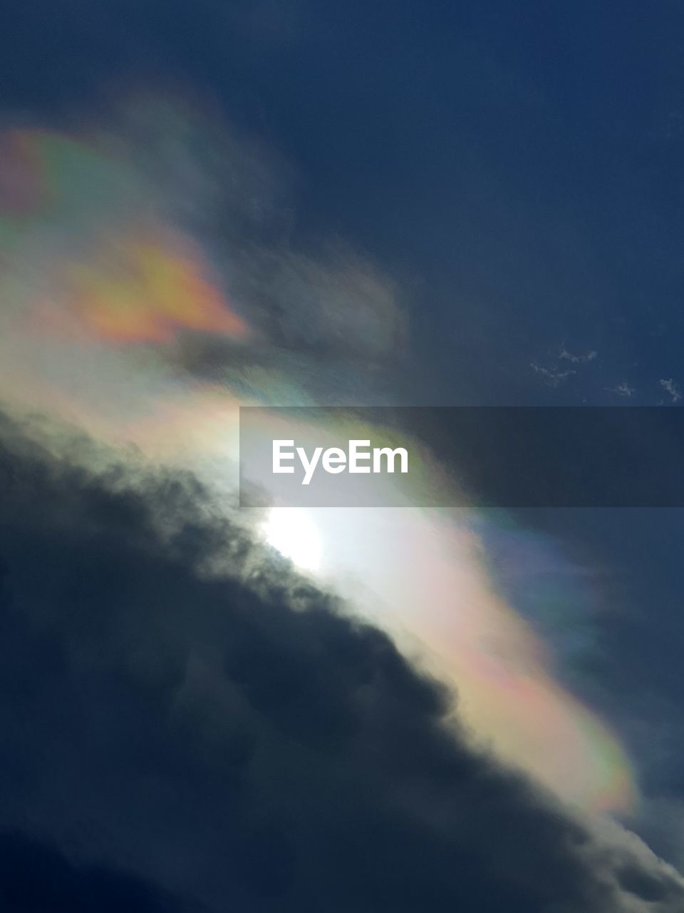LOW ANGLE VIEW OF RAINBOW IN CLOUDY SKY