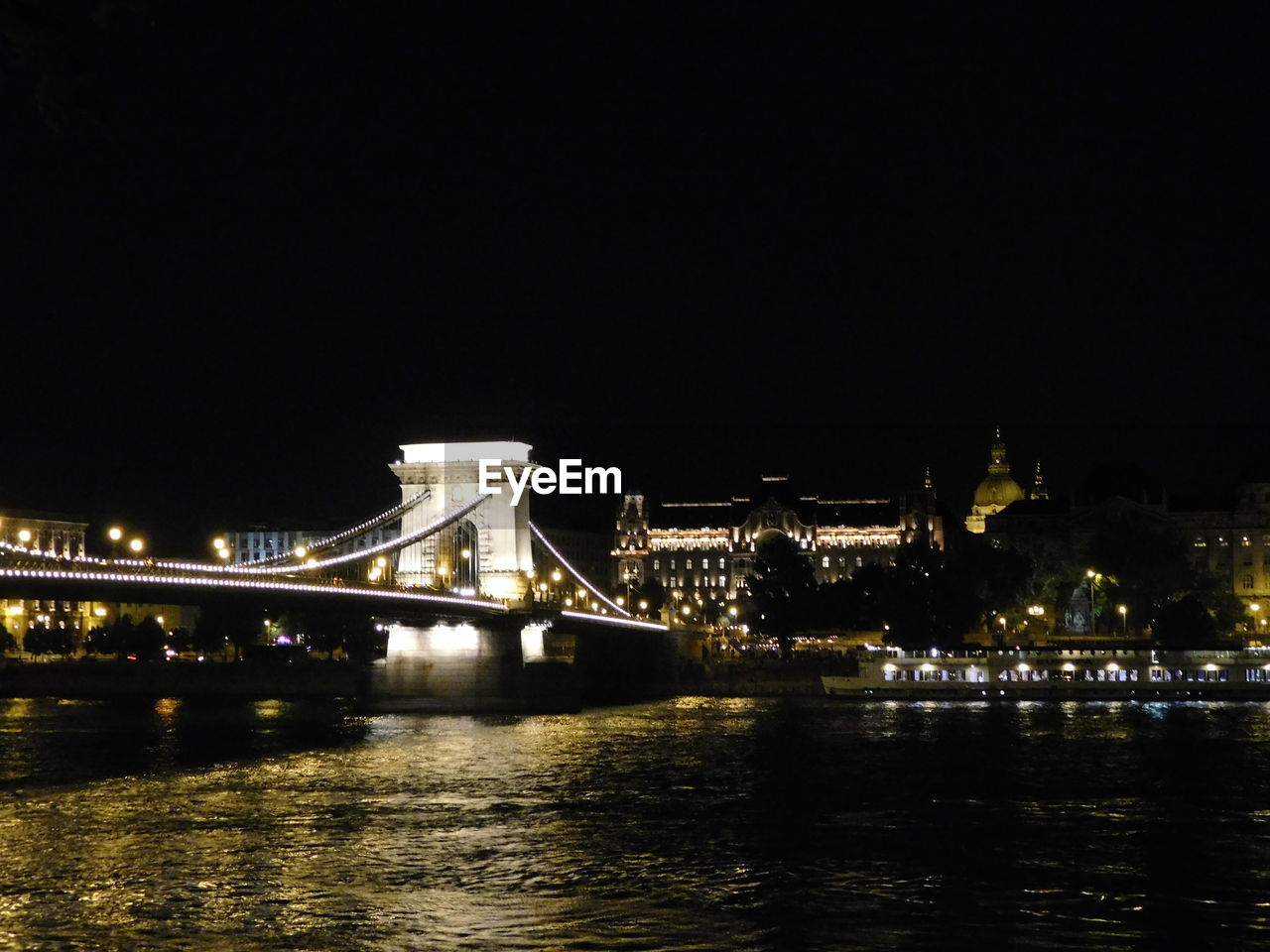 SUSPENSION BRIDGE OVER RIVER AT NIGHT