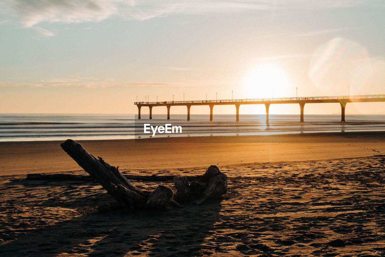 Bridge over sea against sky during sunset