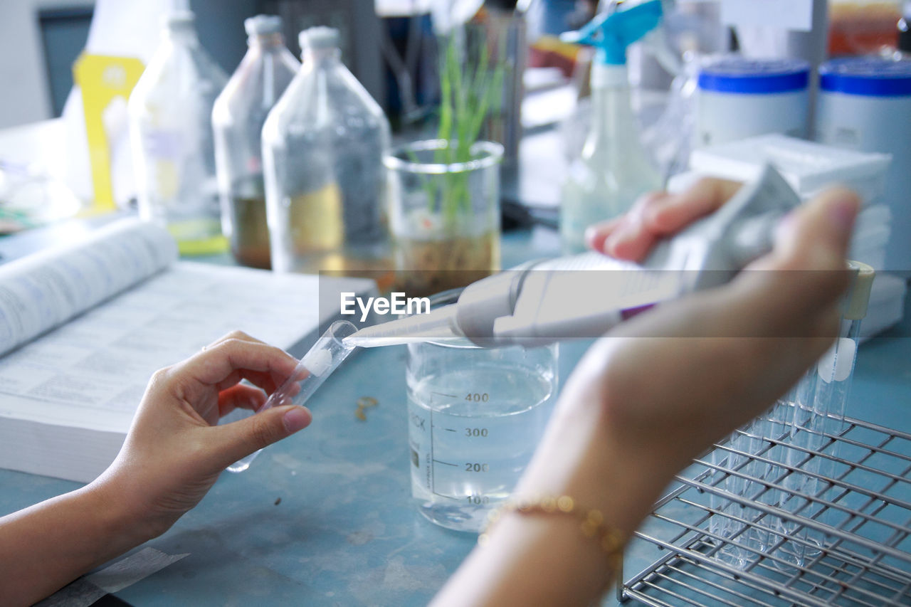 Cropped hands of scientist examining chemical in laboratory