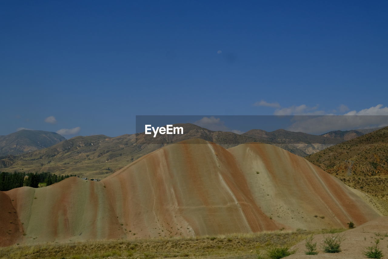 landscape, environment, sky, scenics - nature, mountain, land, nature, valley, natural environment, beauty in nature, desert, no people, plateau, mountain range, non-urban scene, blue, tranquility, travel destinations, tranquil scene, travel, outdoors, plant, day, geology, wadi, soil, semi-arid, clear sky, physical geography, arid climate, remote
