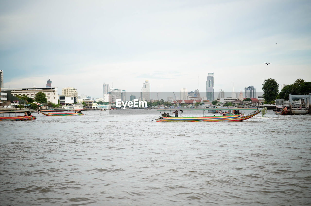 Boats on river against sky