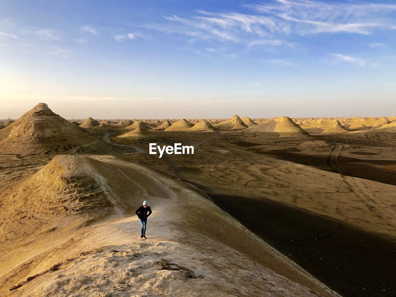 High angle view of girl standing at desert against sky