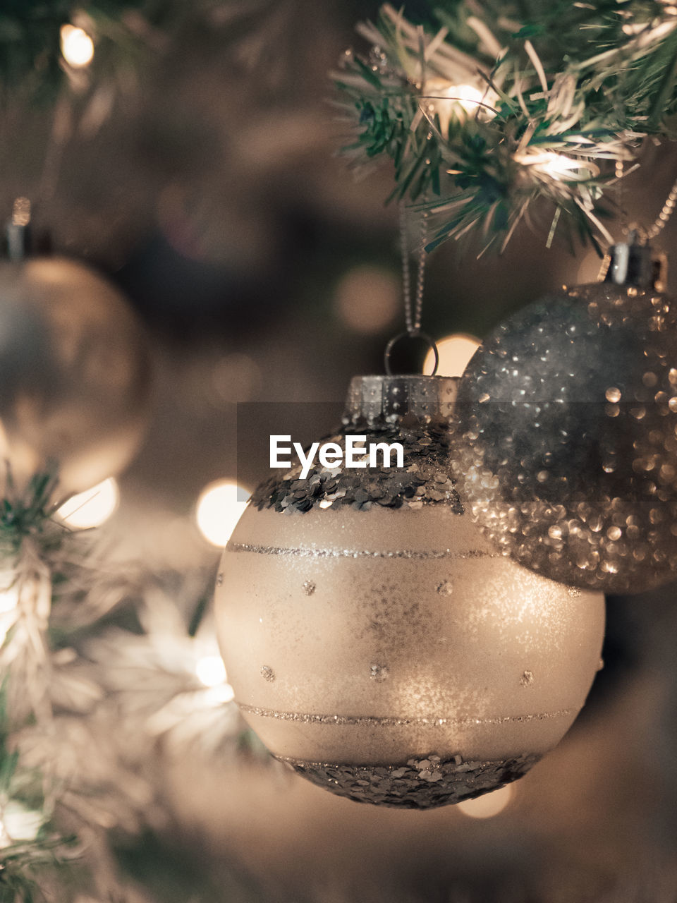 Christmas tree ornaments in warm orange glow and bokeh balls