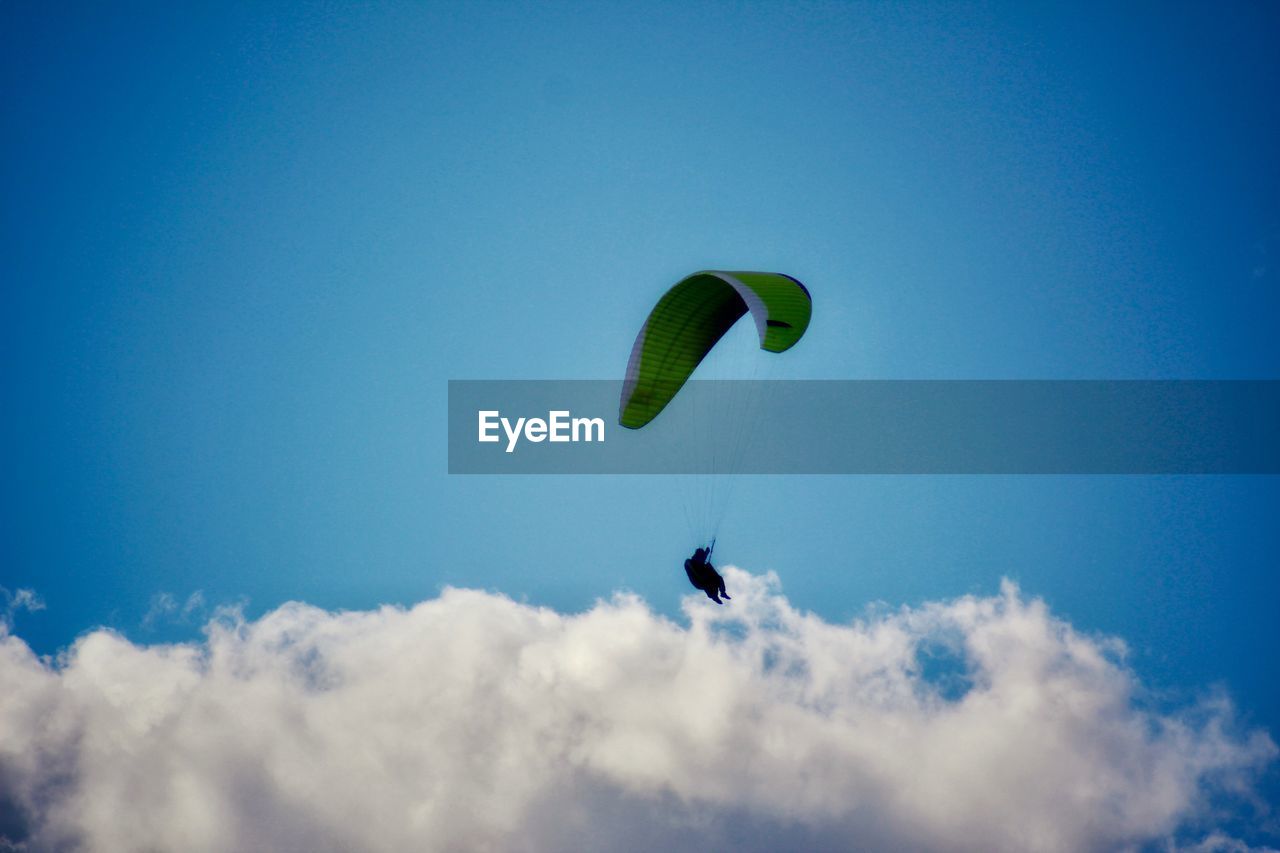 LOW ANGLE VIEW OF PERSON FLYING AGAINST SKY