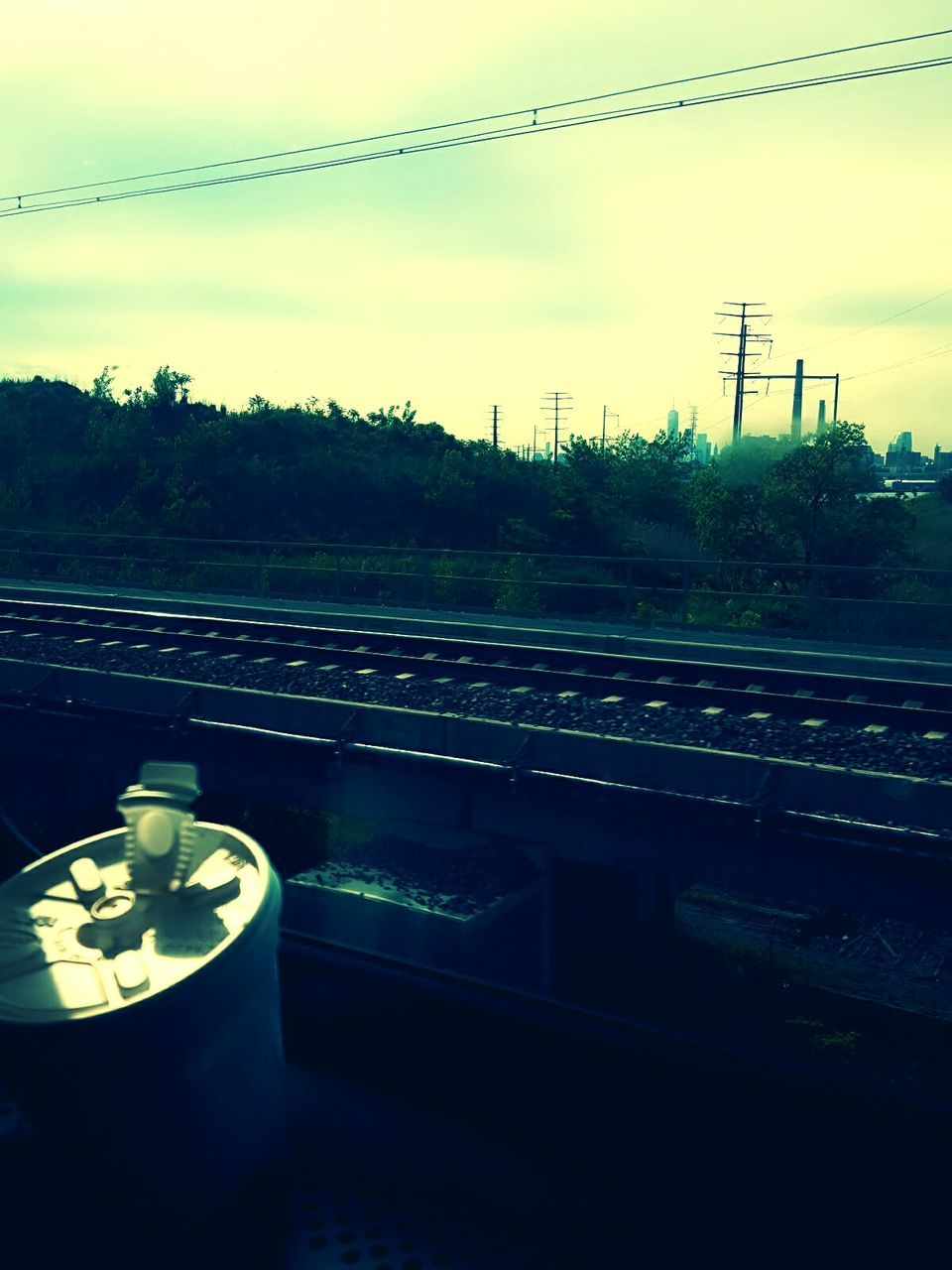 RAILROAD TRACK BY TREES AGAINST SKY