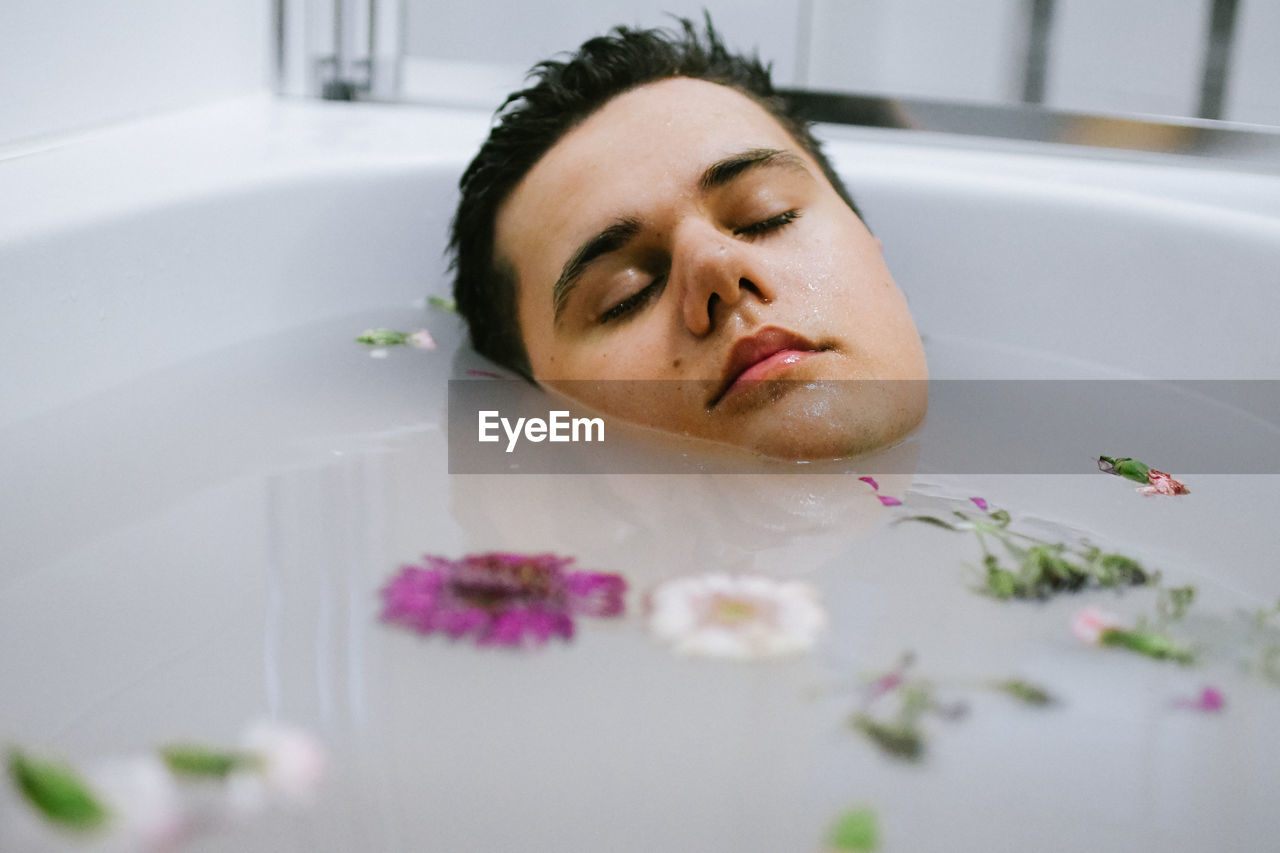 PORTRAIT OF MID ADULT MAN WITH EYES CLOSED IN BATHROOM