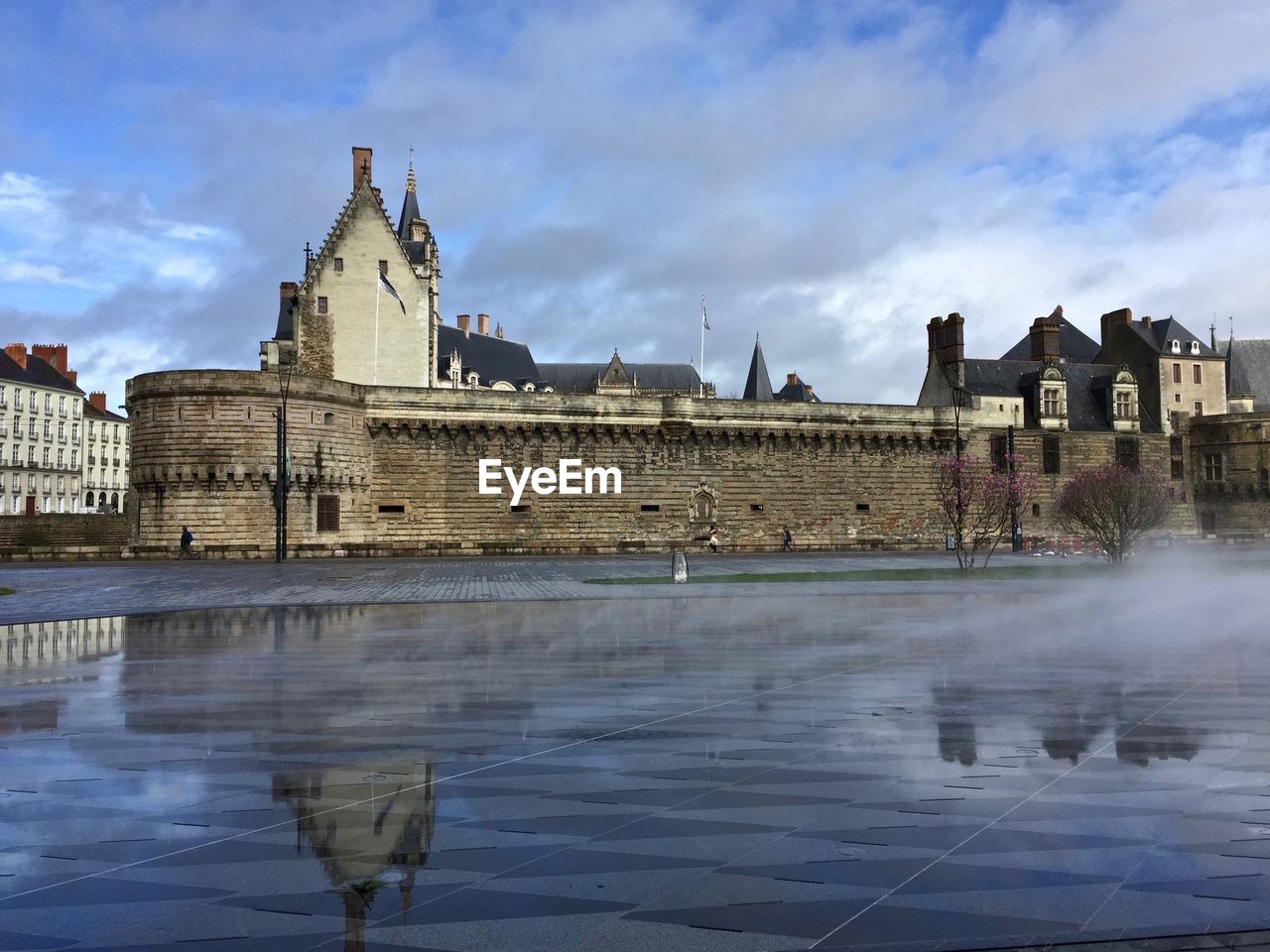 Buildings at waterfront against cloudy sky castle of the dukes of brittany