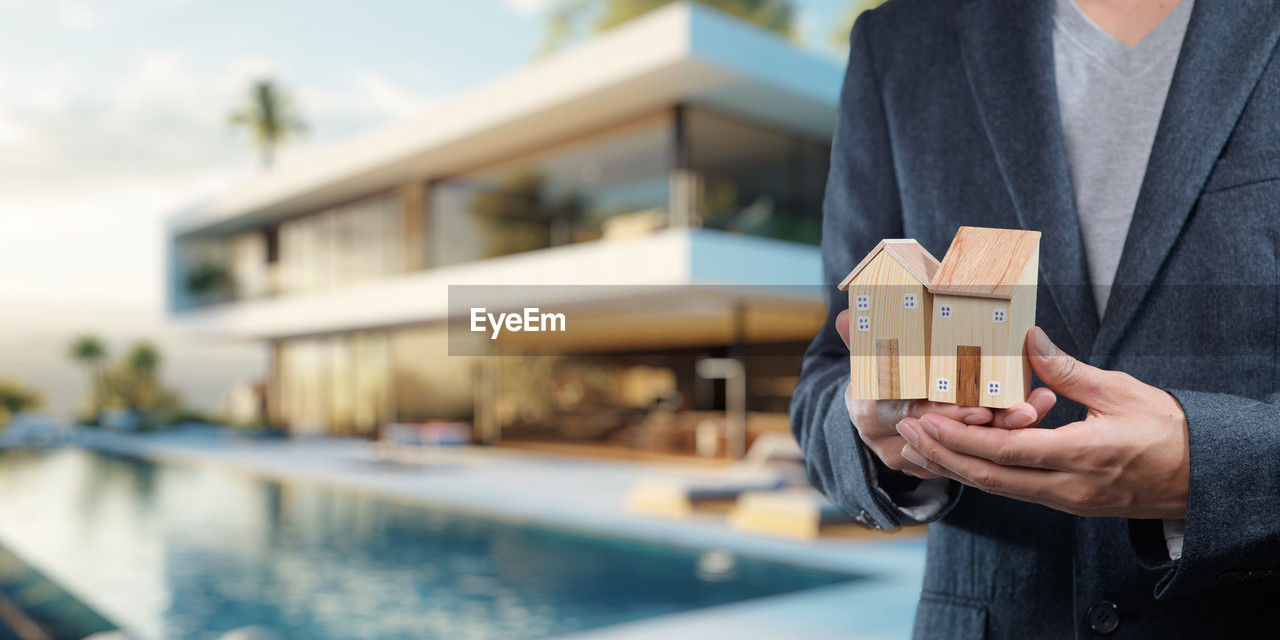 adult, one person, holding, architecture, men, water, business, focus on foreground, standing, day, built structure, outdoors, wealth, building exterior, lifestyles, nature, clothing, finance, midsection, building, activity, person, businessman, front view, business finance and industry