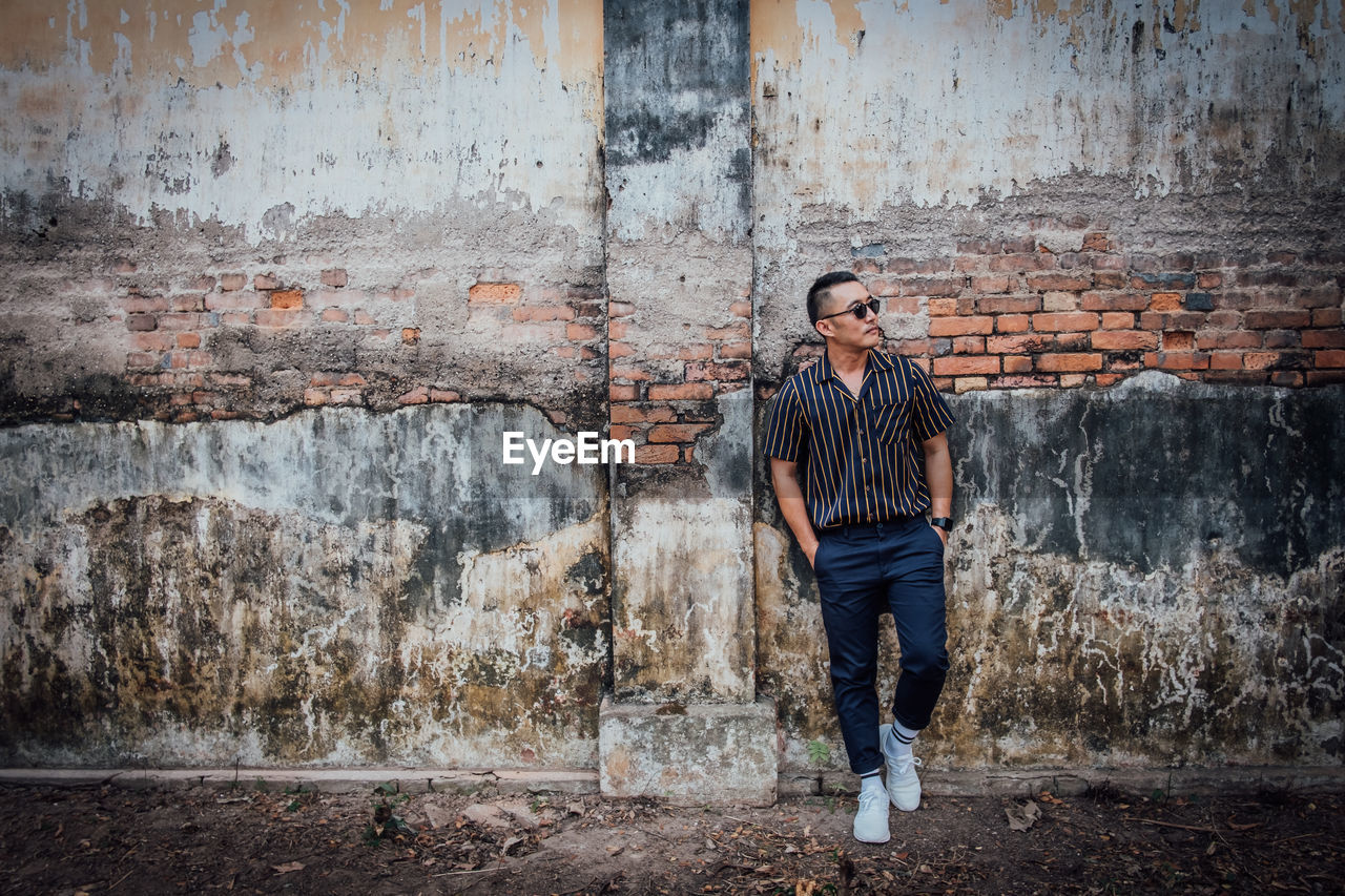 Man standing against wall in city