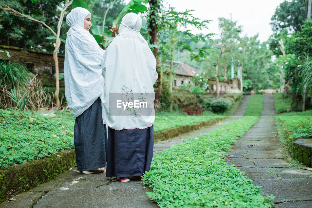 rear view of woman standing on footpath