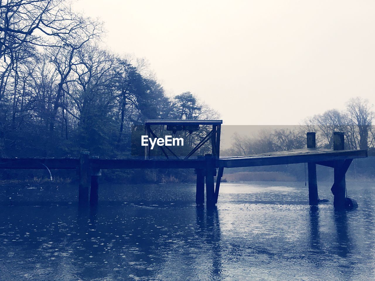 Old pier over lake against clear sky