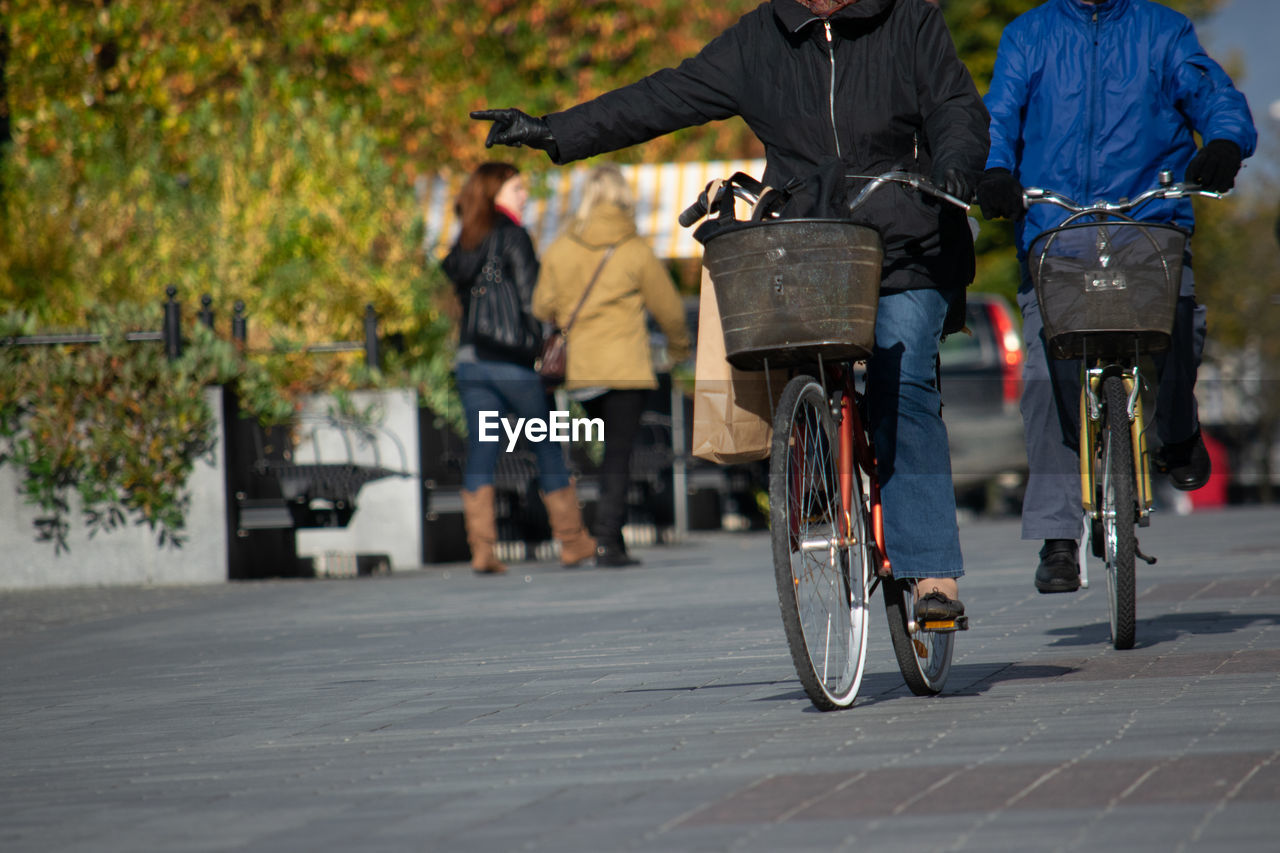 MEN RIDING BICYCLE ON CITY